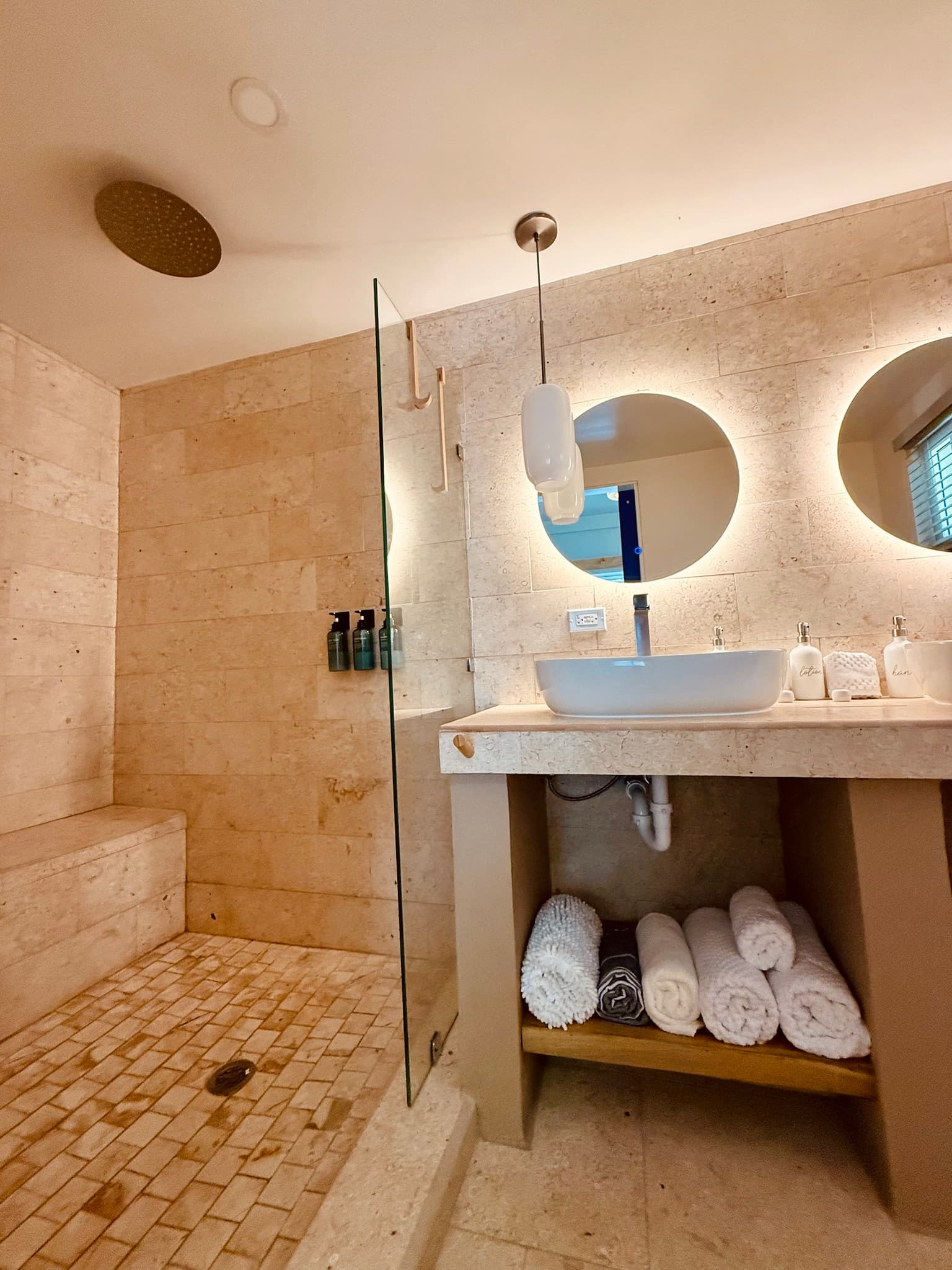 Cool, tiled bathroom with plush towels, beach towels and hairdryer