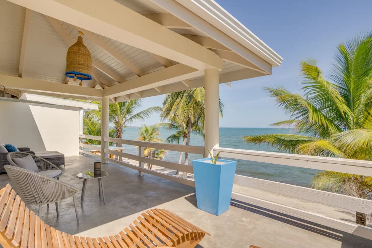 Contemporary outdoor lounge area with ocean view and palm trees.