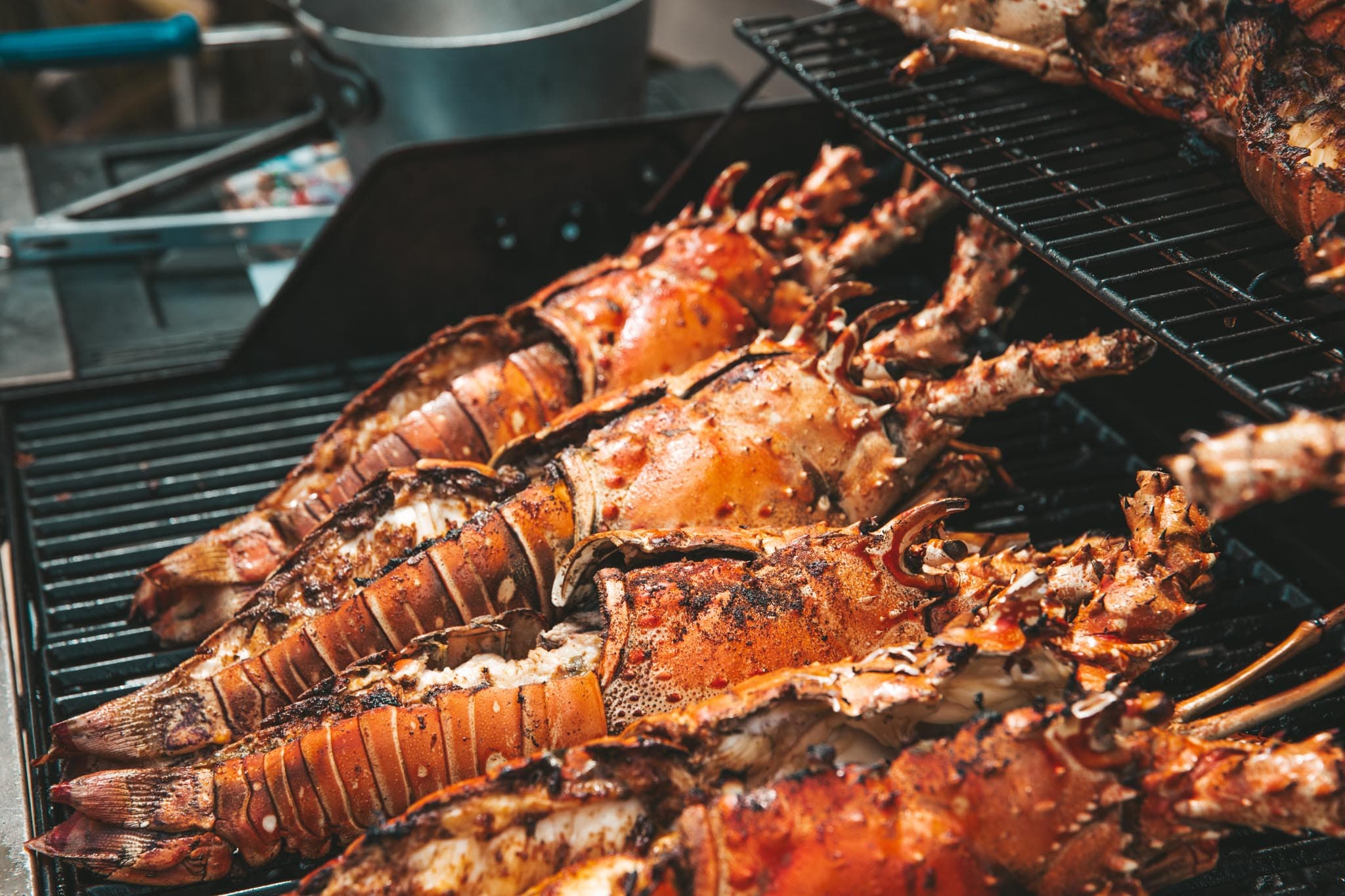 Grilled lobsters sizzling on a barbecue grill.