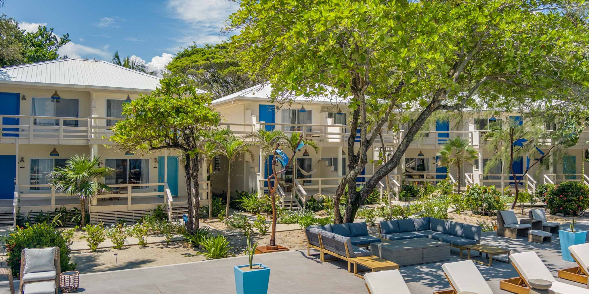 A serene resort featuring two-story buildings surrounded by lush greenery and outdoor seating areas.