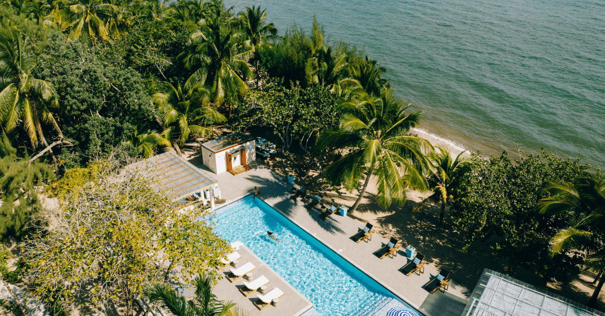Guest enjoying a relaxing swim in the beachfront pool at Blue Reef Beach & Marina surrounded by tropical scenery and coastal views.