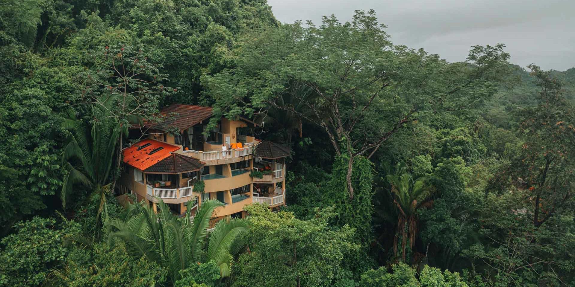 Aerial view of the Mountain View Suites nestled among lush rainforest greenery at Sleeping Giant Rainforest Lodge, Sibun River Valley, Cayo District, Belize