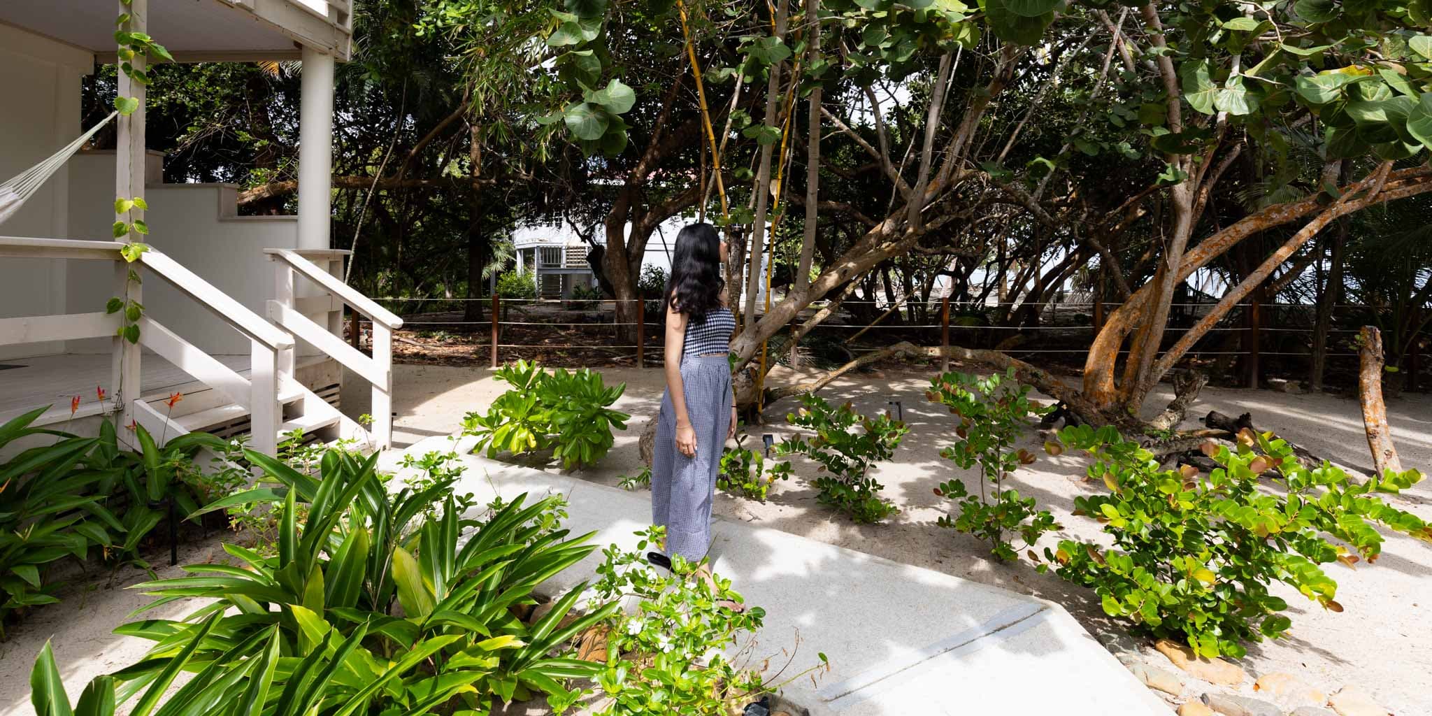 A guest walking outside of their pool view room at Blue Reef Beach Resort in Placencia Belize