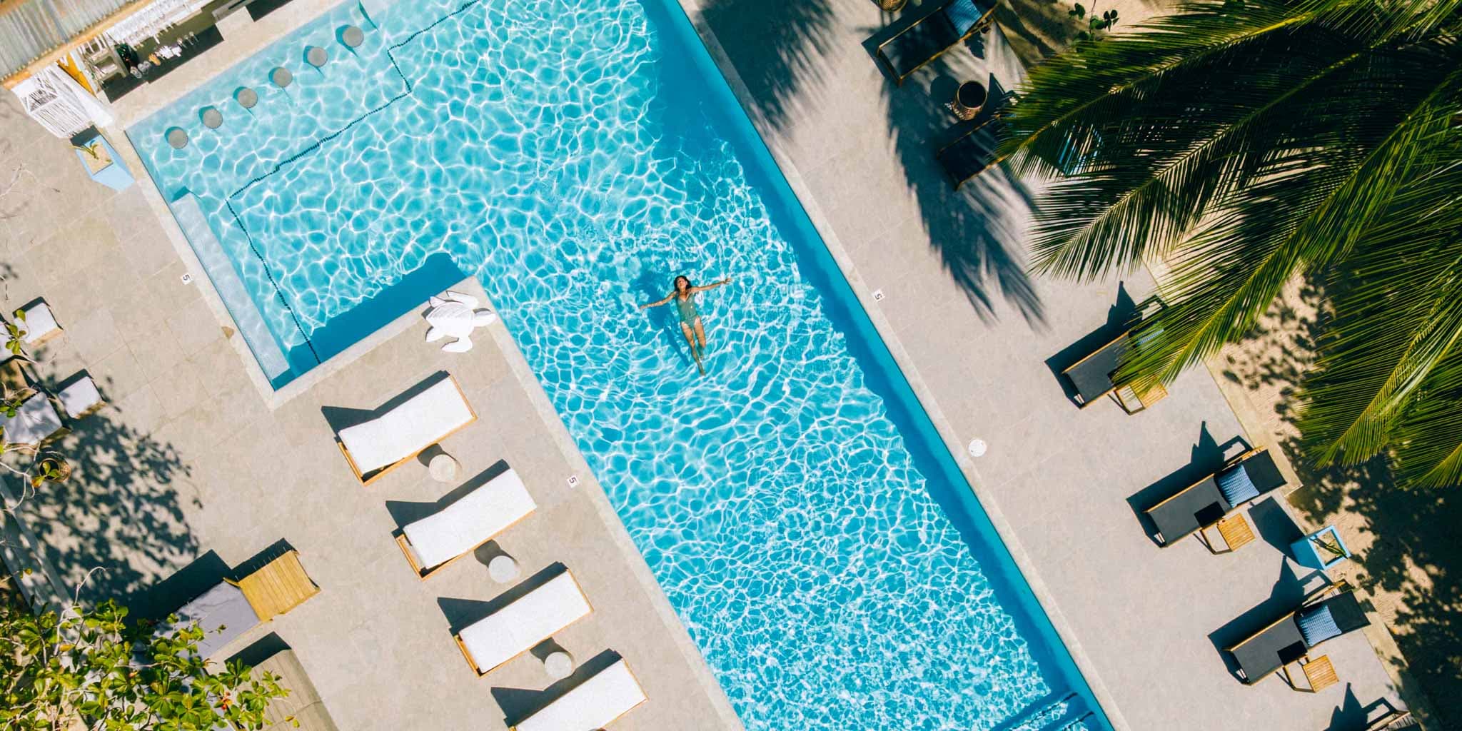 An aerial shot of a guest swimming in the pool at Blue Reef Beach Resort in Placencia