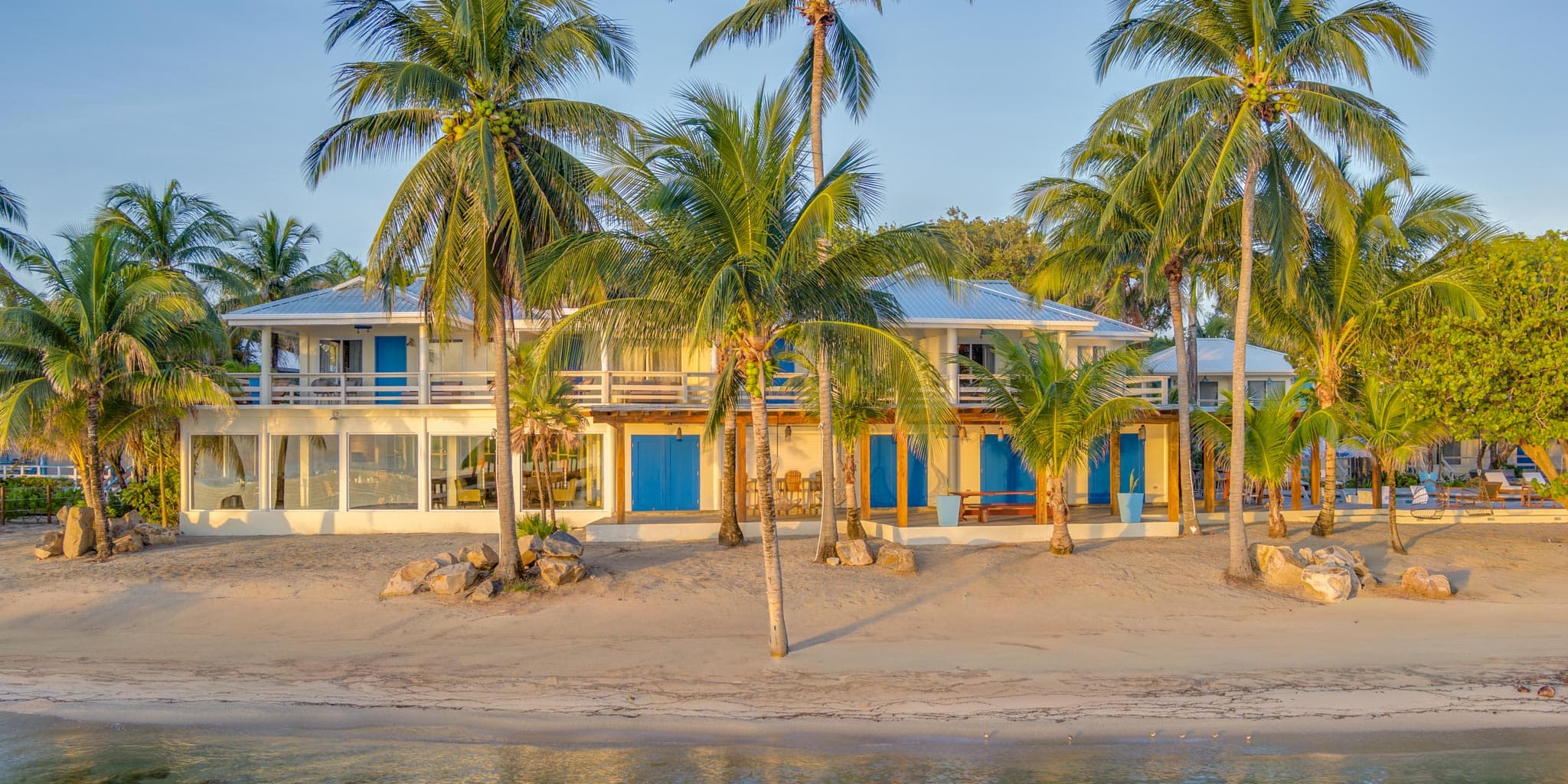 Bamboo Beach Bistro with beachfront swing seating and outdoor dining area at Blue Reef Beach Resort, Placencia Peninsula, Stann Creek District, Belize