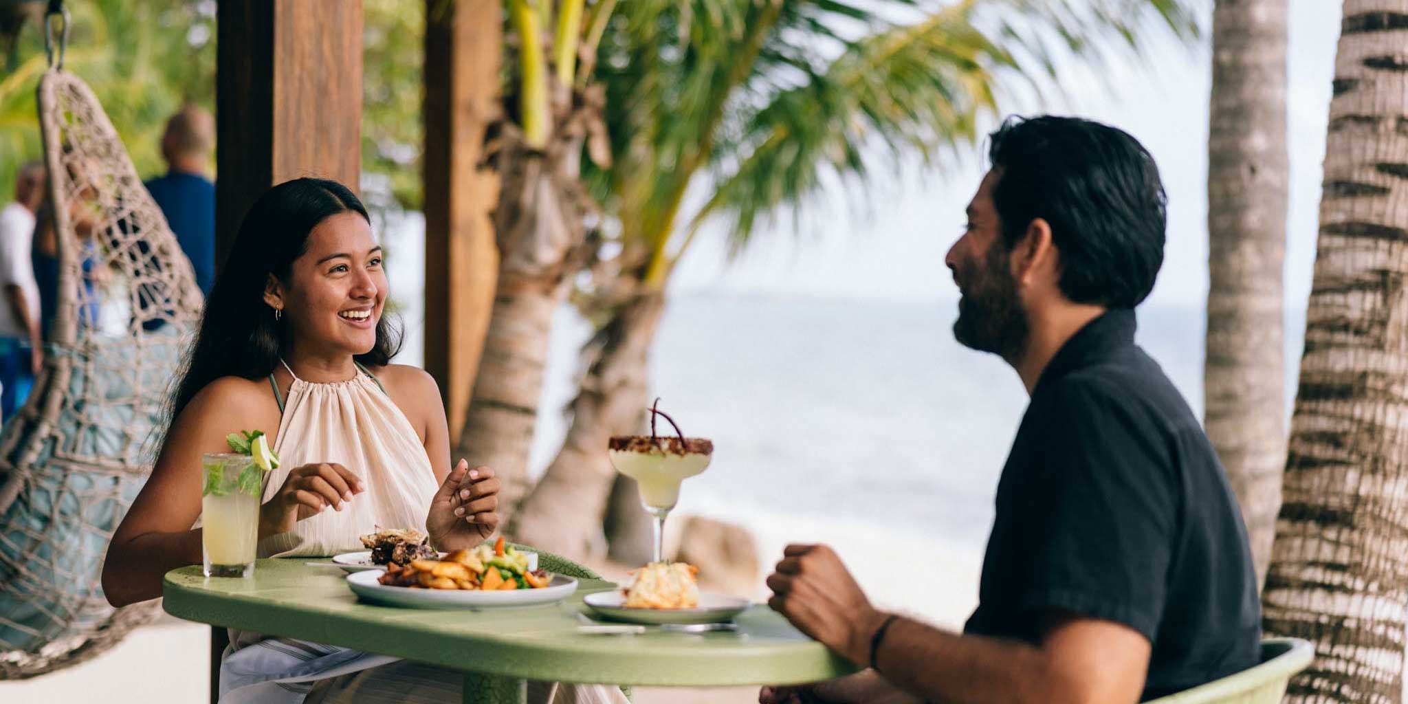 A couple having lunch at Bamboo Beach Bistro at Blue Reef Beach & Marina in Placencia