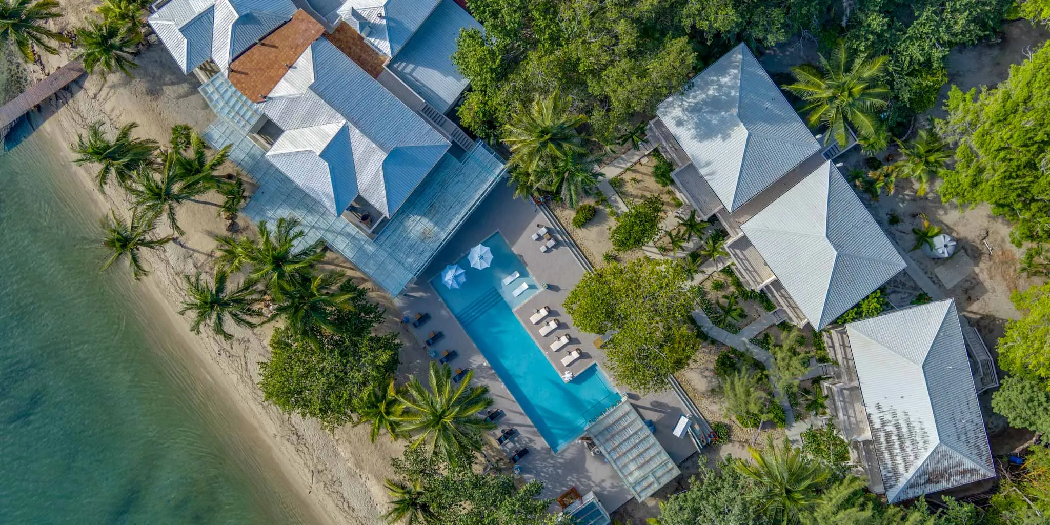 Aerial view of the suites and the pool surrounded by greenery at Blue Reef Beach Resort in Placencia