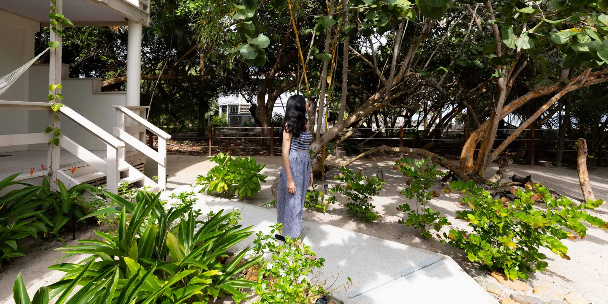 A guest walking outside of their pool view room at Blue Reef Beach Resort in Placencia Belize