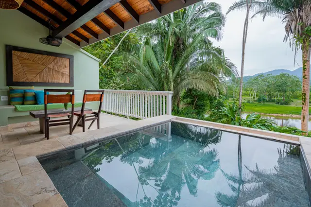 Piscina de inmersión y zona de estar en balcón privado con vistas al río y a la exuberante selva en Sleeping Giant