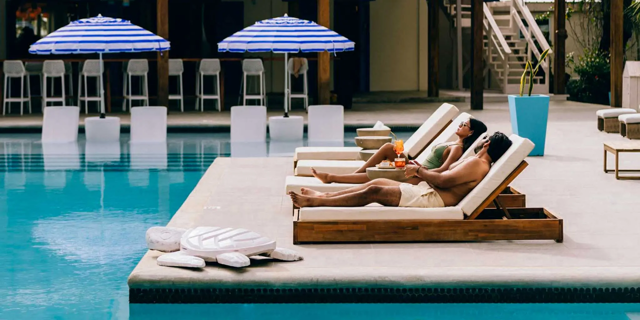 A couple relaxing by the poolside at Blue Reef Beach Resort on the Placencia Peninsula in Belize